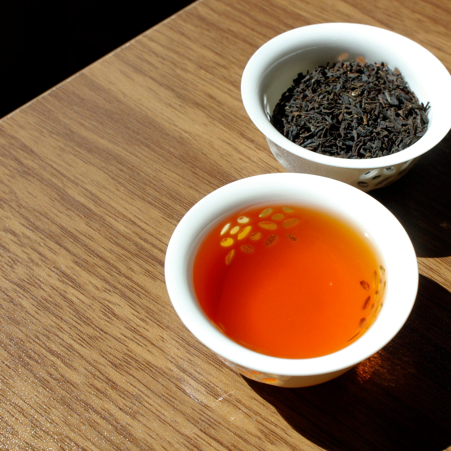 Assam: Chardwar Estate - infusion, tea leaves in a separate cup in the background. Tasting Notes:
orange peel • whole wheat toast • oak