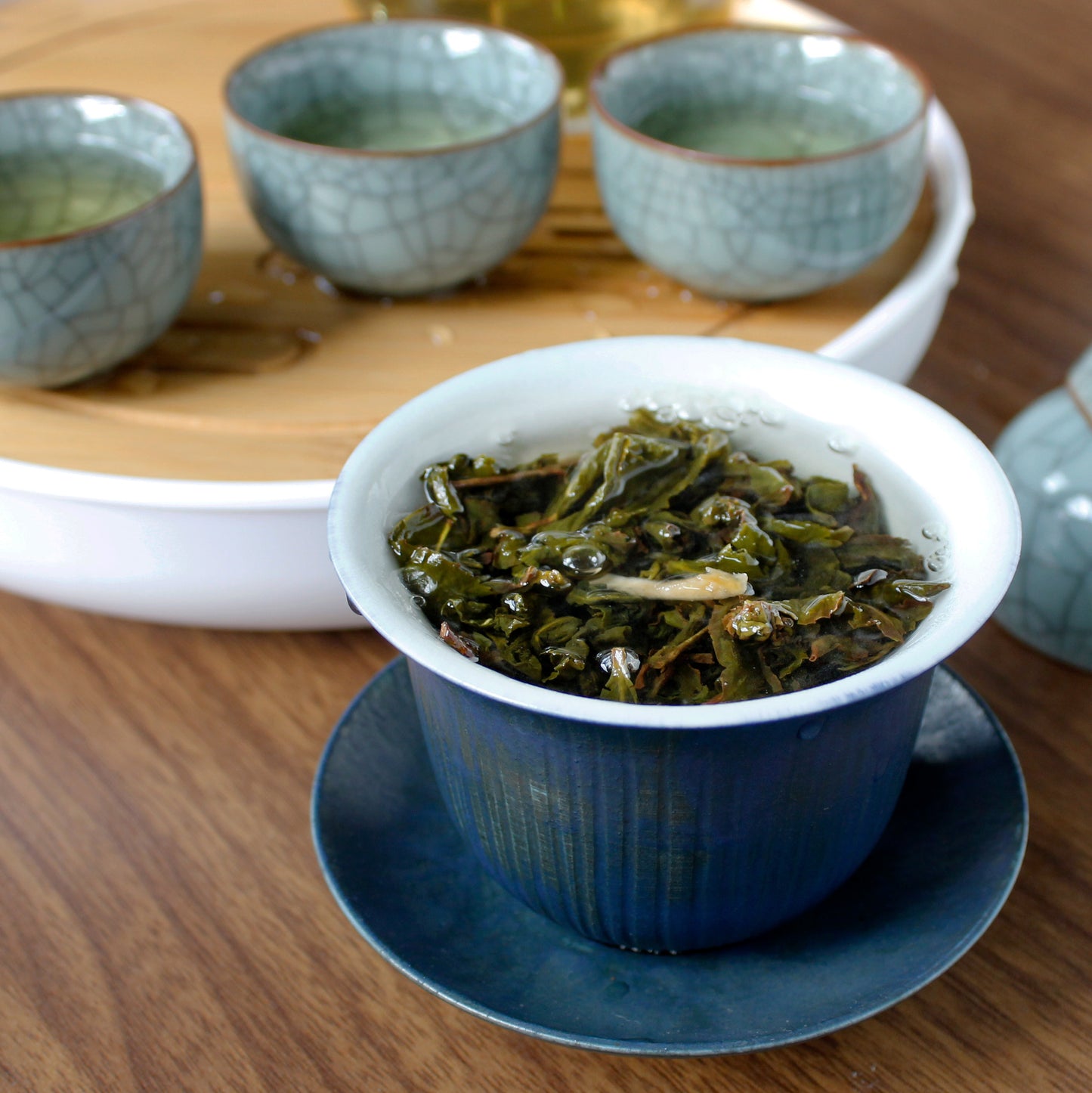 Bergamot Oolong - steeping in a blue tea cup with a tea tray and cups in the background. Tasting Notes:
lilac • limoncello • verbena
