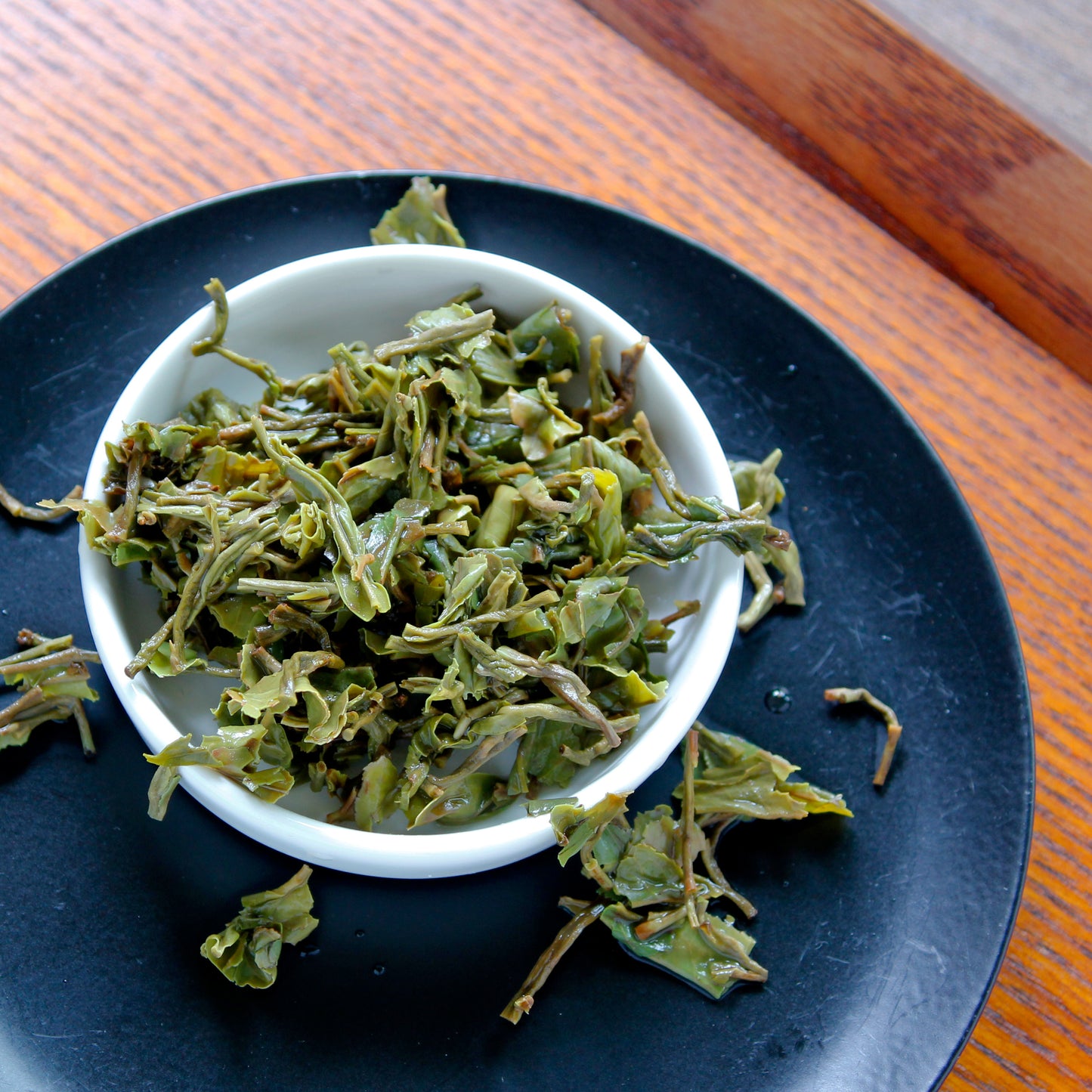 Darjeeling 1st Flush: Jungpana Estate - wet leaves in a white bowl on a black plate. Tasting Notes:
asparagus • pomelo • tangerine