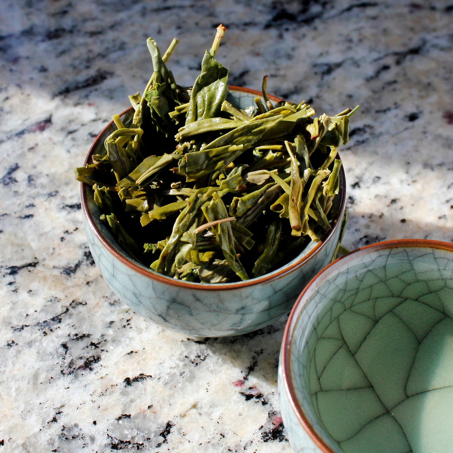 Wet leaves in a tasting cup on marble table. Tasting Notes:
frisée • swiss chard • brazil nut