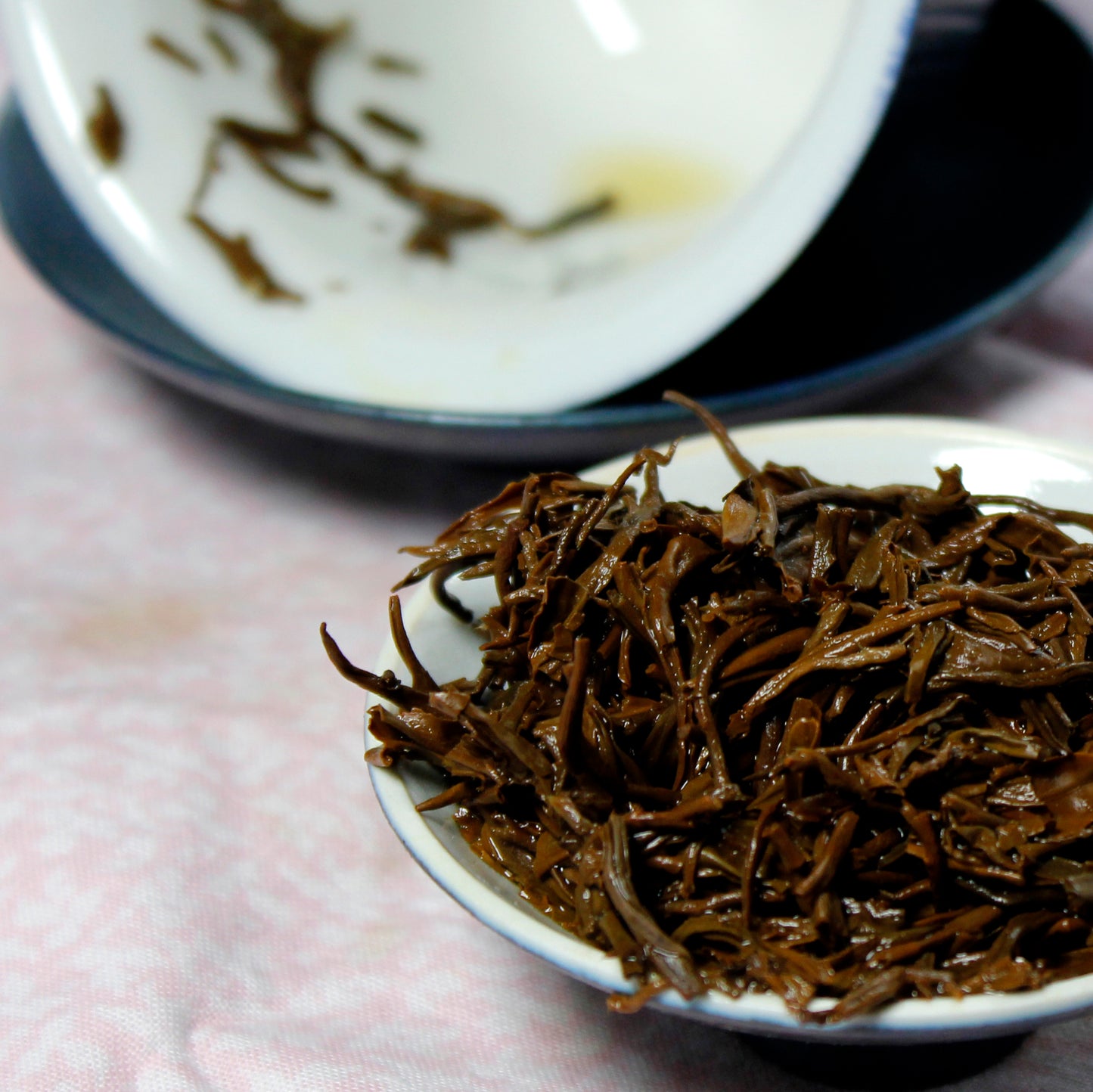 Wet tea leaves on a white dish. Tasting Notes:
burnt sugar • cocoa • rose