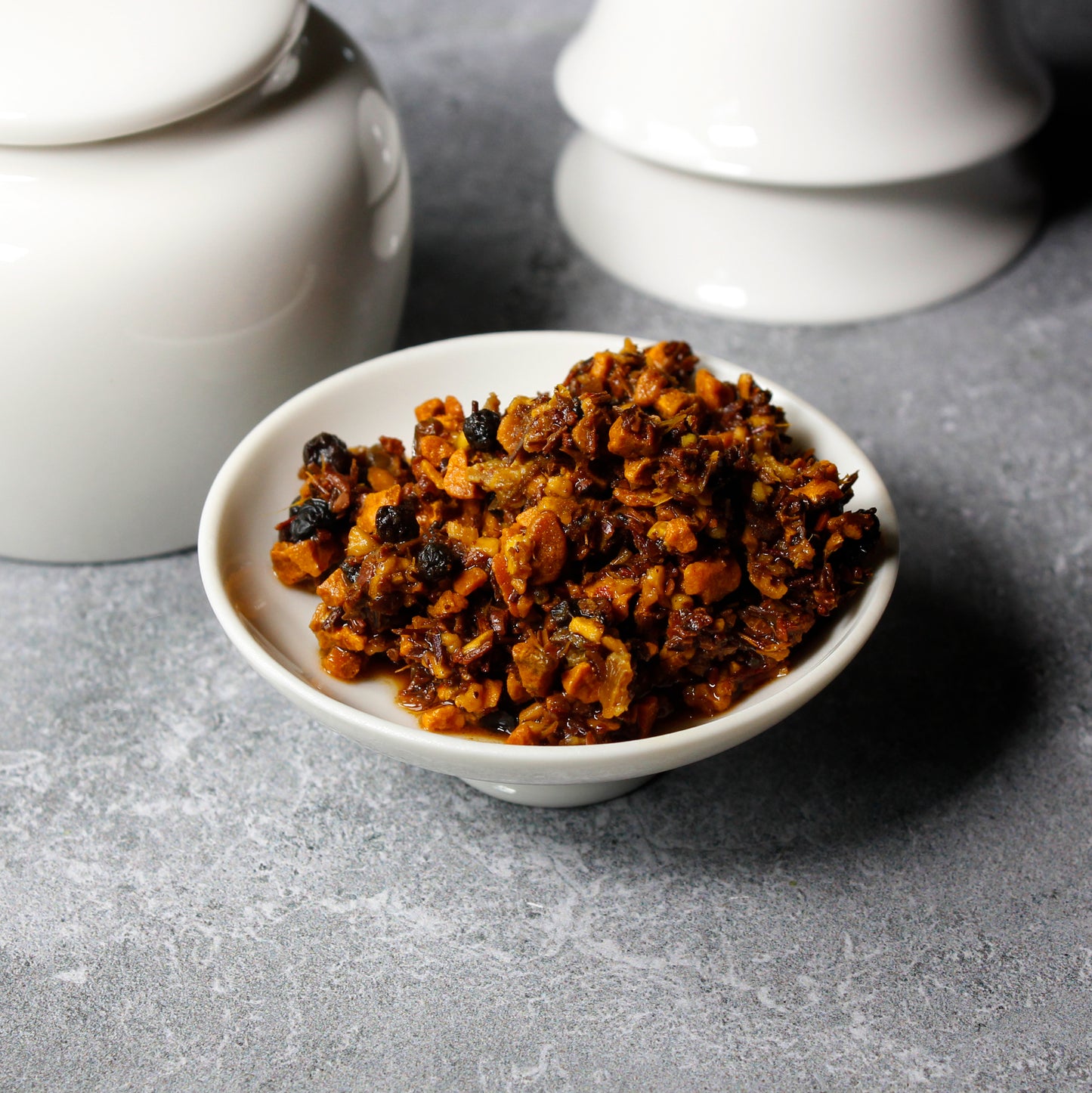 Golden Chai - wet leaves on a white dish, teacups in the background. Tasting Notes:
ginger • citrus • turmeric