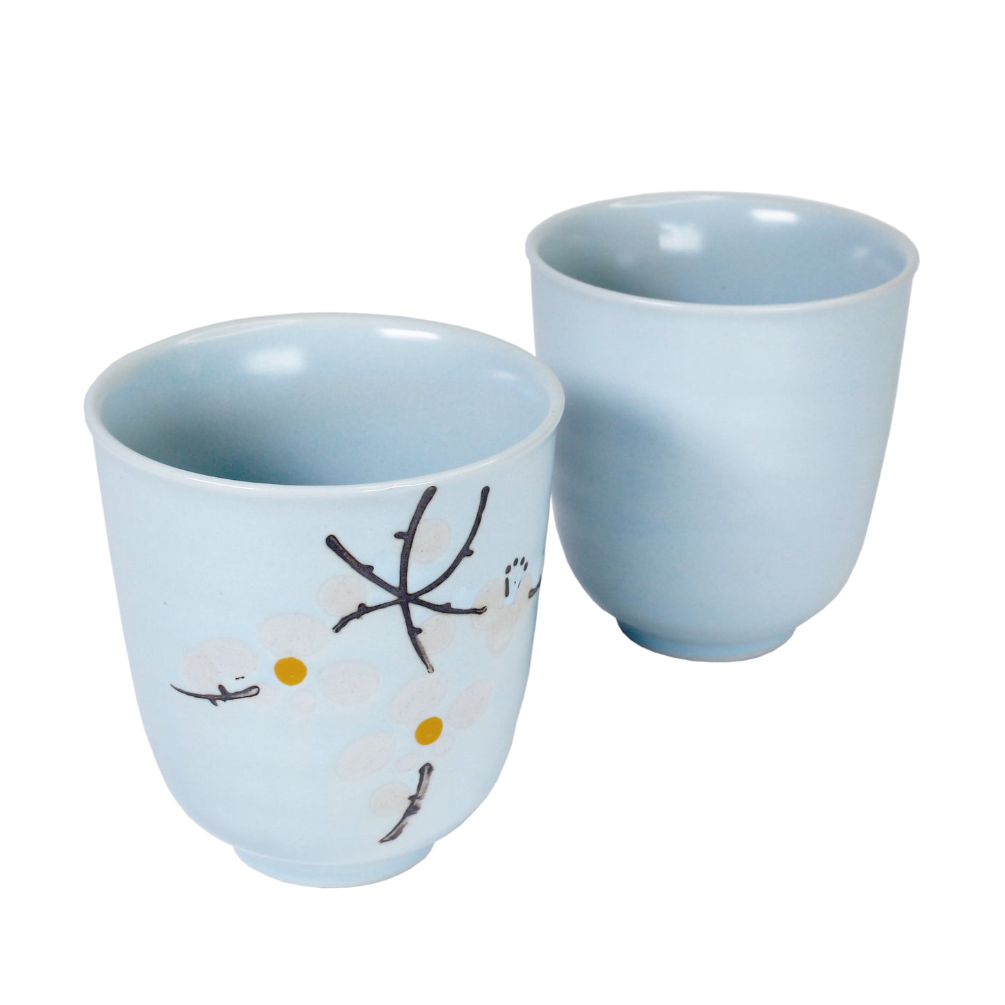 Sakura ceramic teacups, one showing the floral pattern on a white background.