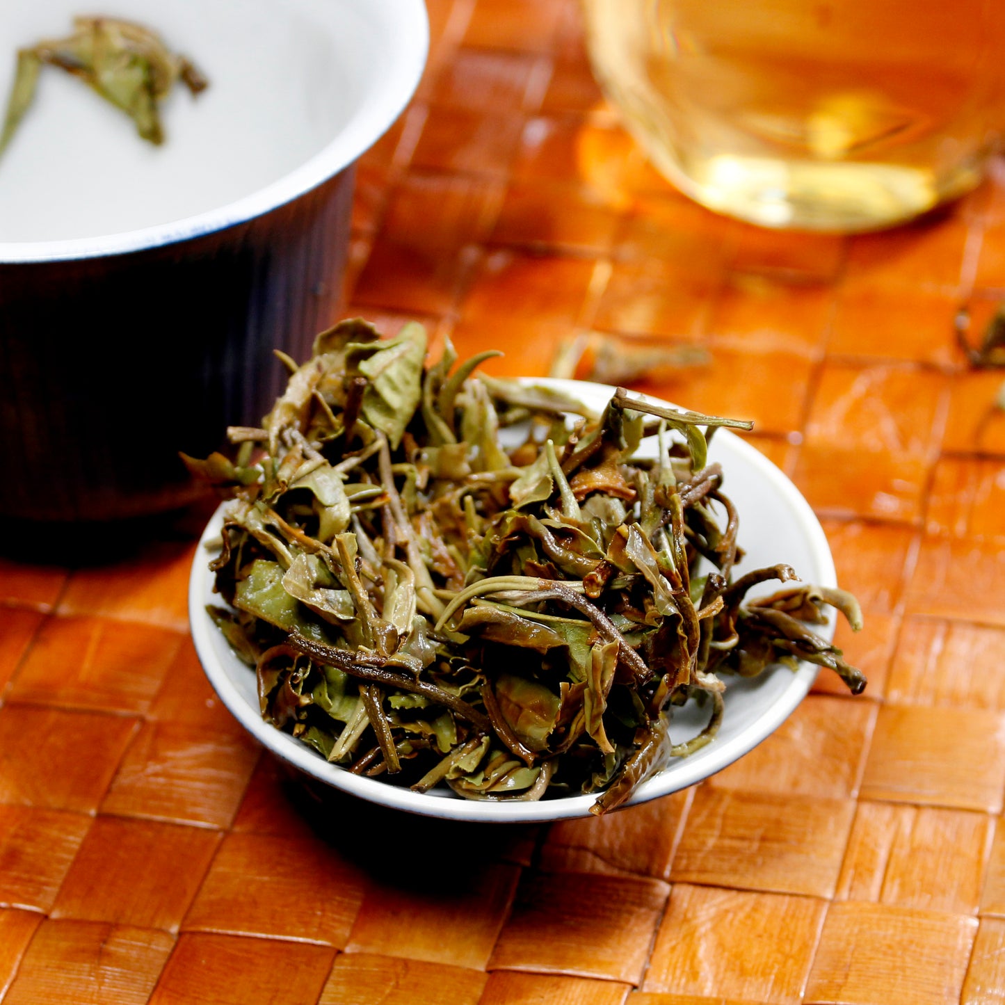 White Peony: Bai Mu Dan - wet leaves on a dish with cup and pitcher in the background. Tasting Notes:
chrysanthemum • honeycomb • linden flower