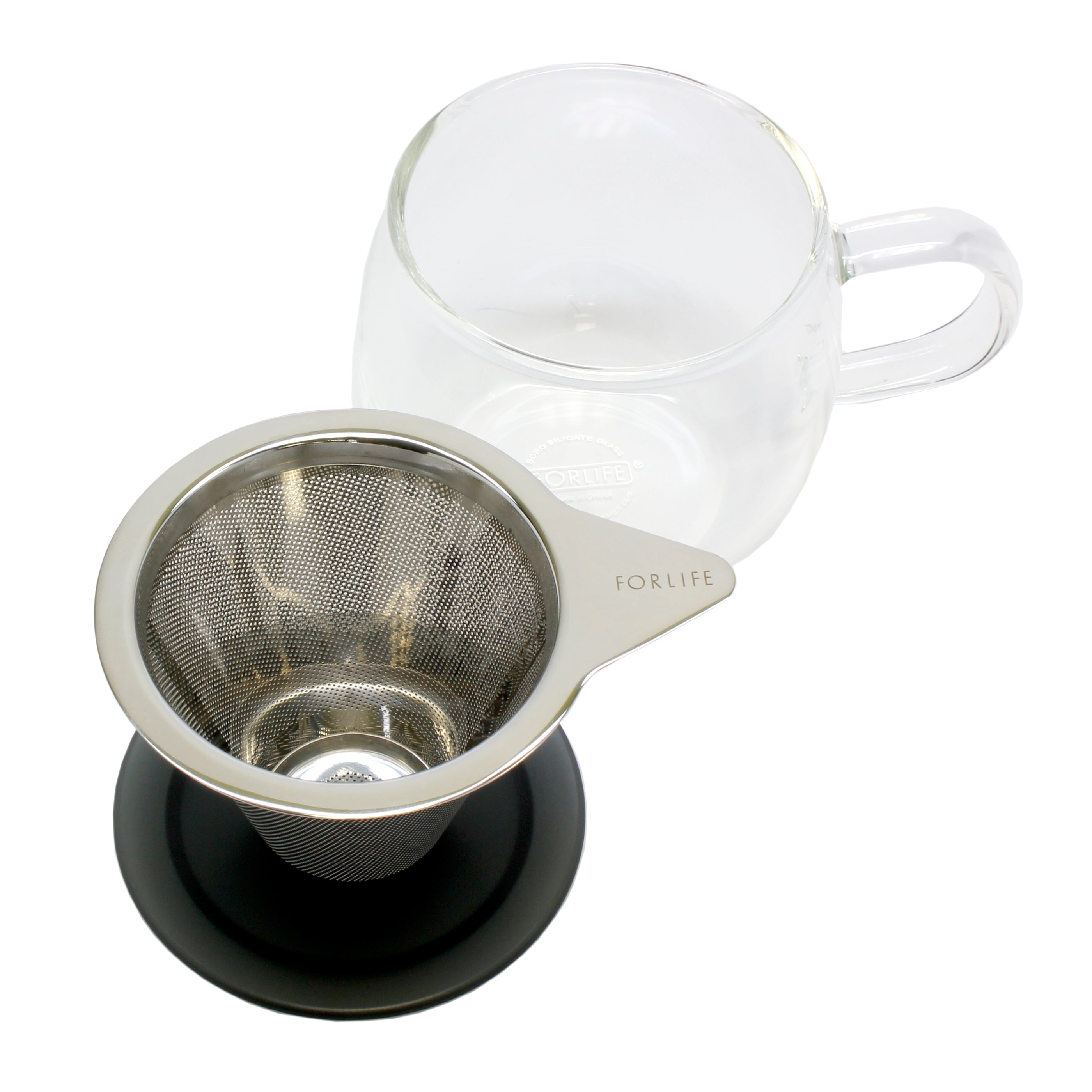 An empty strainer sits on a black lid with the mug in the background