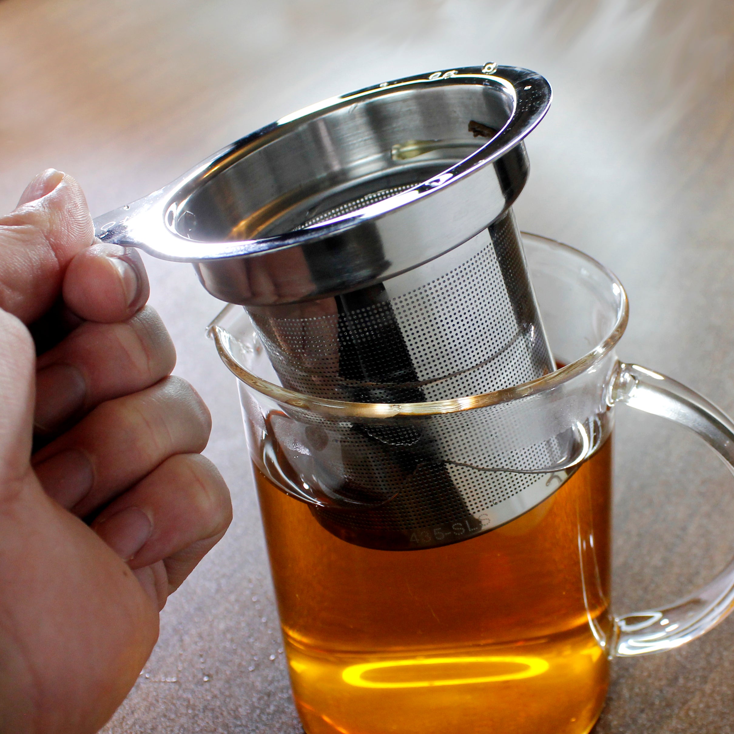 Tea strainer being lifted out of a mug