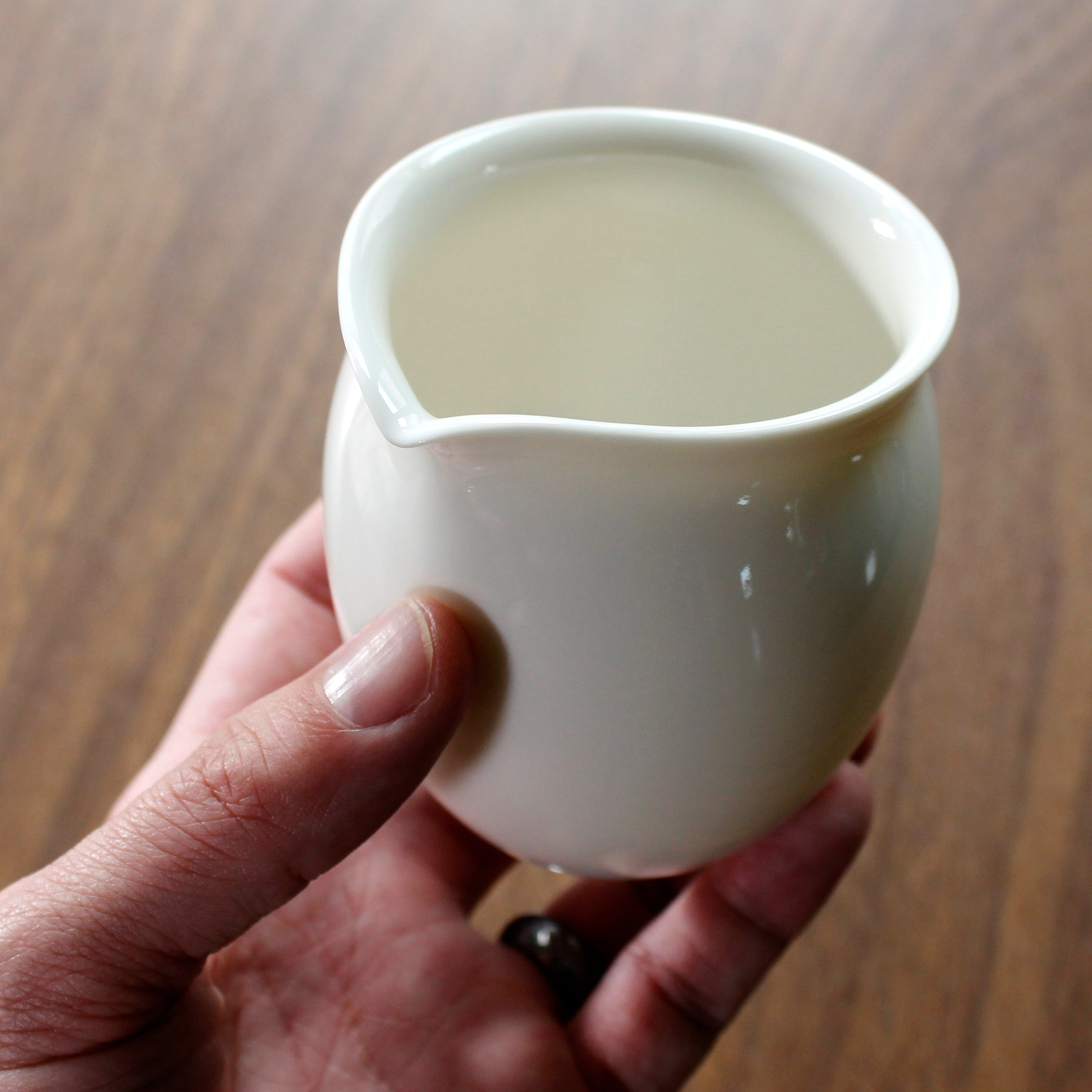 Hand holding the pitcher from the bottom.