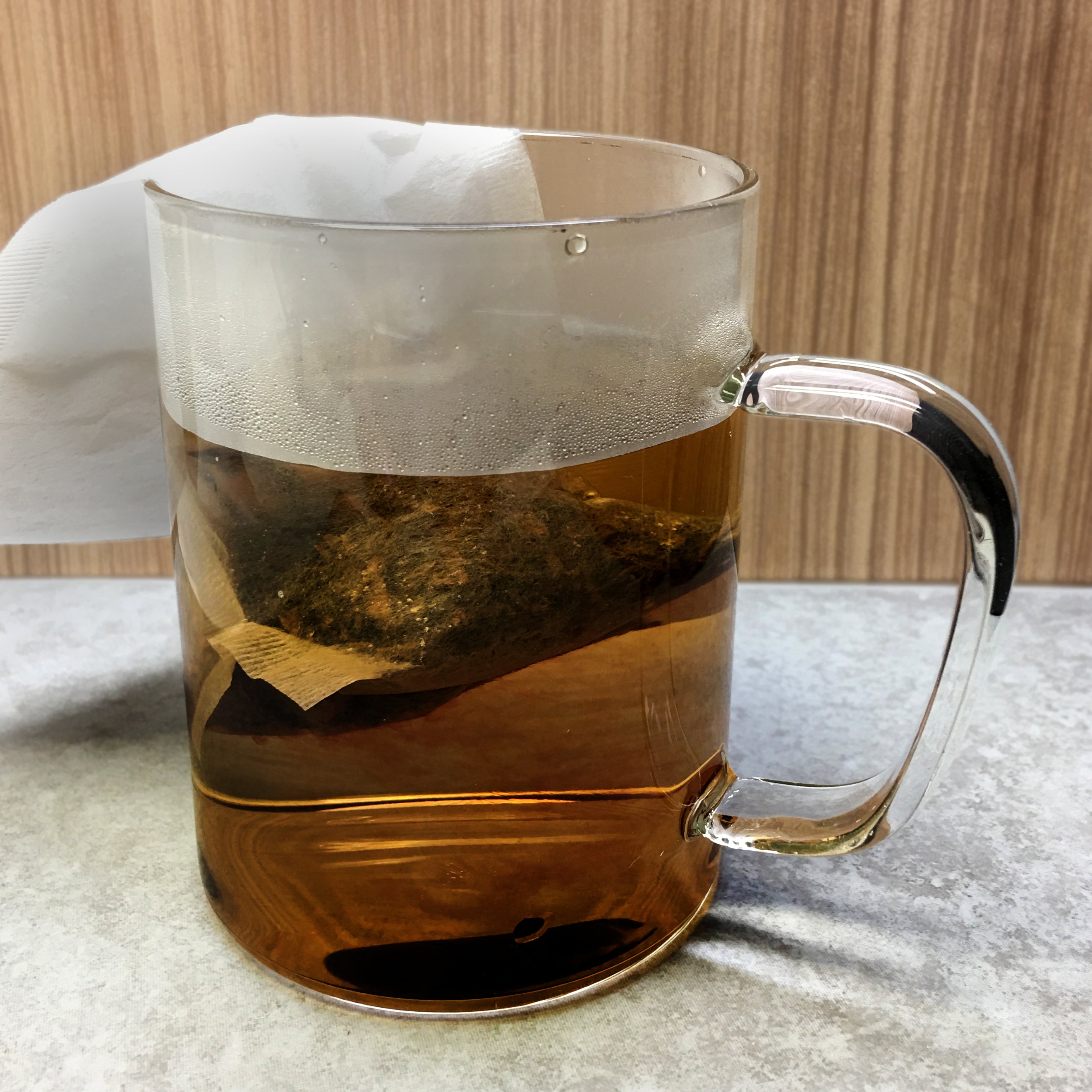 Tea bag in hot water in a glass pitcher. 