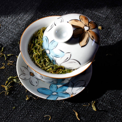 Ceramic gaiwan with floral design on a dark surface