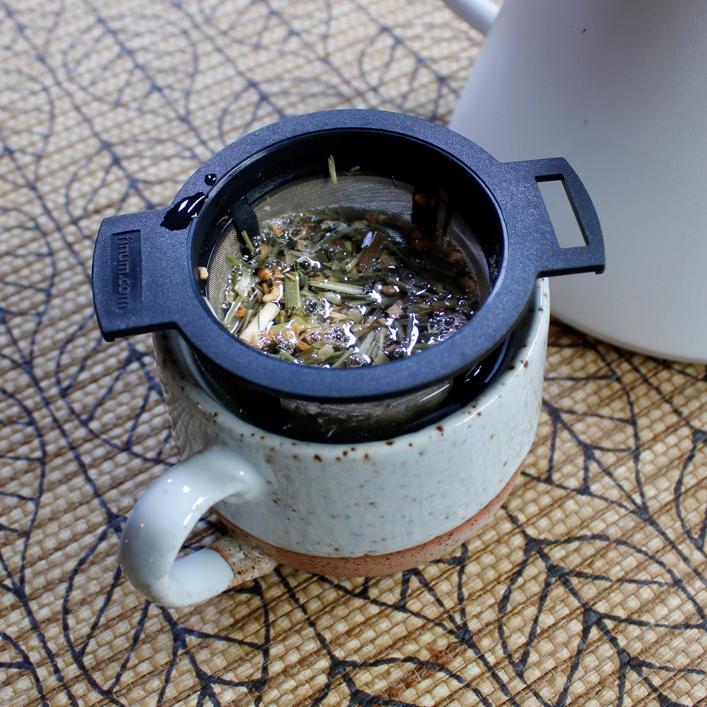 Ginger Lemon - steeping in a tea strainer in a speckled mug on a pattern table cloth. Tasting Notes:
honey • citron • ginger