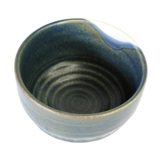 Green chawan matcha bowl with white blue spot on the side on a white background. 
