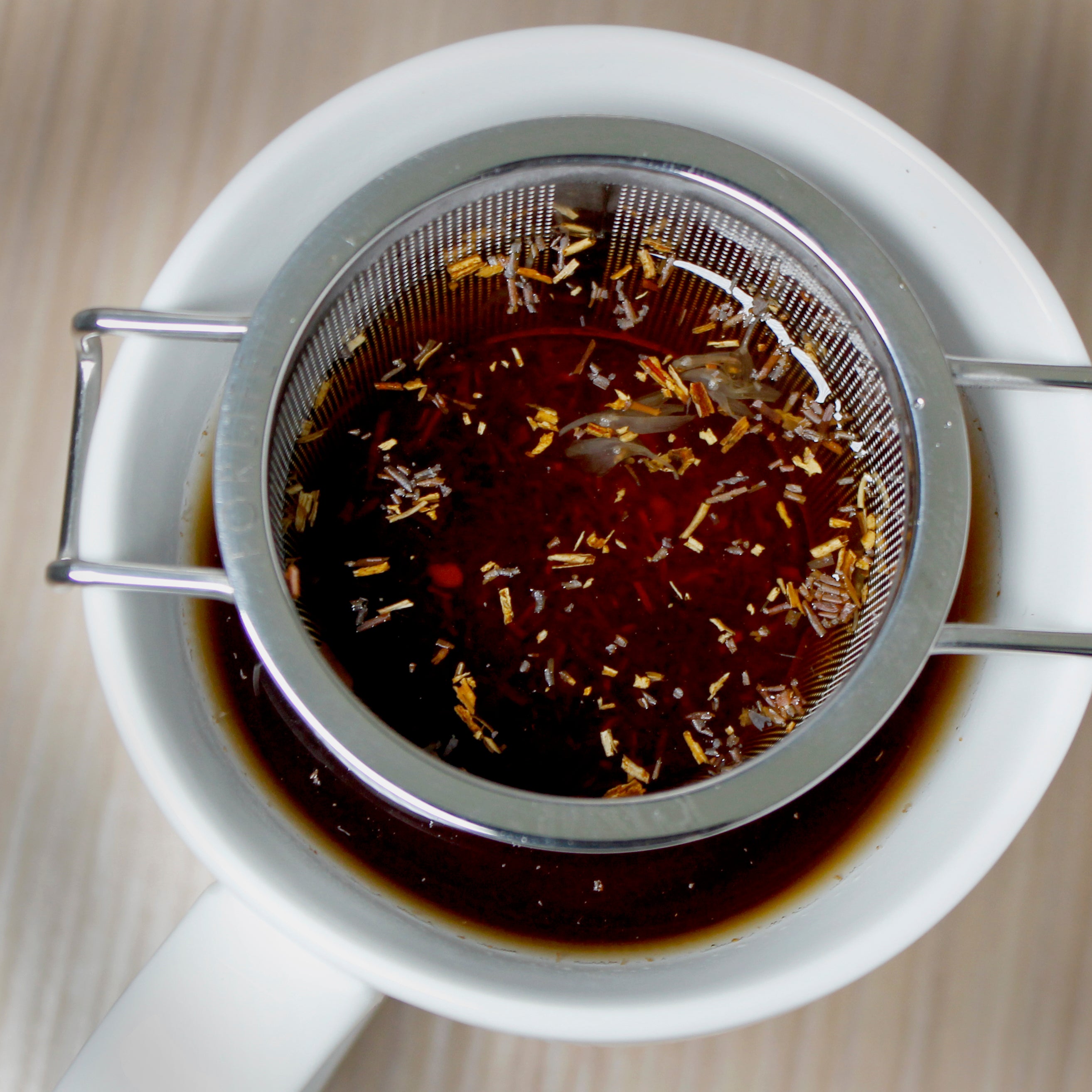 Strainer with tea in white mug. 